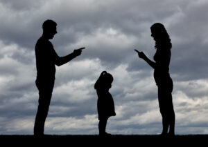 Two parents standing on either side of a child, signifying a child custody dispute