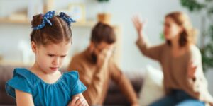 A child looks upset as his parents fight