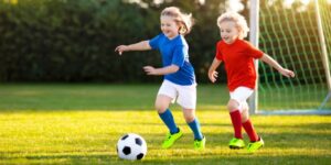 A young child playing soccer as an after school activity