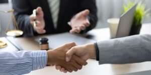 Two hands shaking as they go through divorce mediation