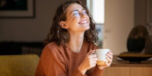 Woman smiling while holding a cup of coffee