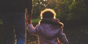 Child holding a parent's hand outside